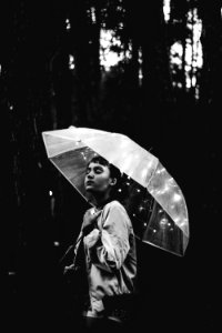 Grayscale Image Of Woman Walking Through The Rain While Holding Umbrella photo