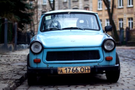 Classic Blue Car Parked Near Fence And Trees