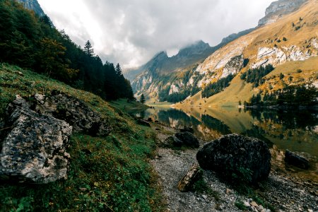 River Between Mountains Under Cloudy Sky photo