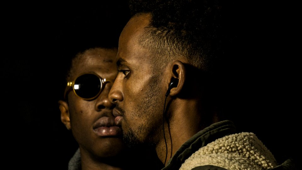 Man Wearing Earphones Near Man In Sunglasses