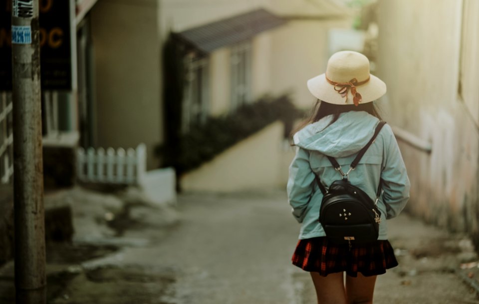 Girl In Blue Jacket And Black Leather Knapsack Walking On Street
