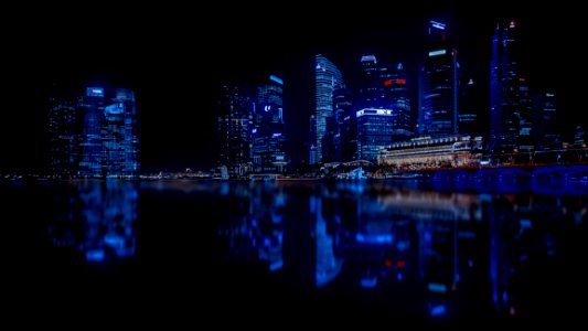 Illuminated Cityscape Against Blue Sky At Night