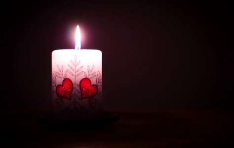 Close-up Of Illuminated Candle Against Black Background photo