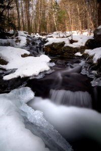 Water Flowing Through Snow Covered Forest photo