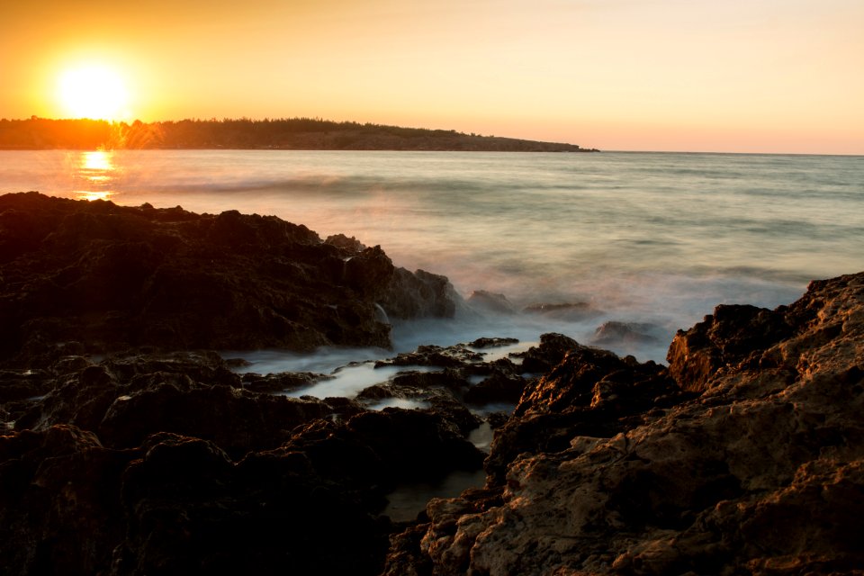 Scenic View Of Sea Against Dramatic Sky During Sunset photo