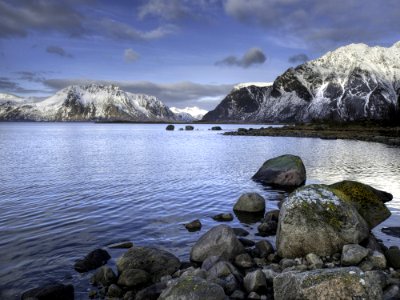Black And Gray Rock Formations Beside Blue Body Of Water photo