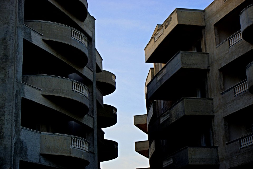 2 Brown High Rise Building Facing Each Other At Daytime