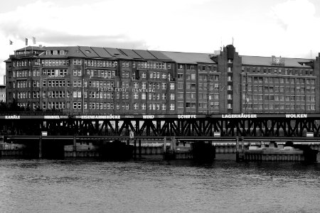 Grayscale Photo Of Mid Rise Building Near Body Of Water At Daytime photo