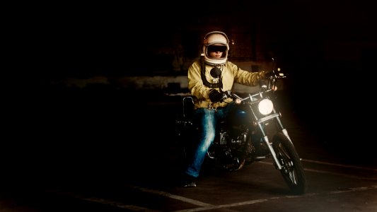 Man Wearing White Full Face Helmet Riding On Standard Motorcycle photo