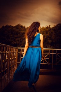Woman Facing Away Wearing Blue Tank Long Dress Looking Out To Trees