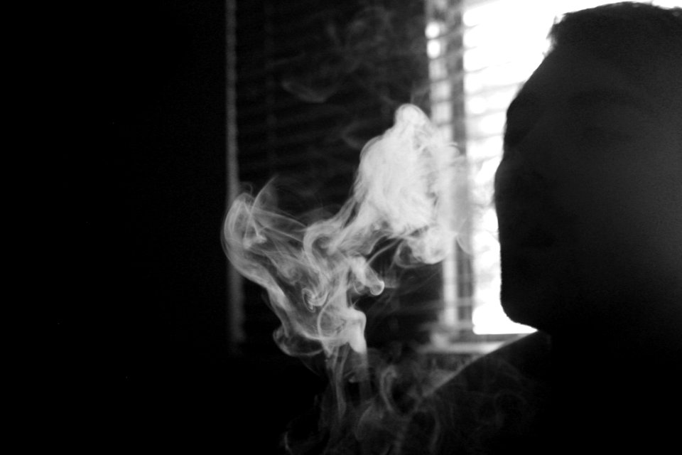 Gray Scale Photo Of Human Smoking Inside The Room