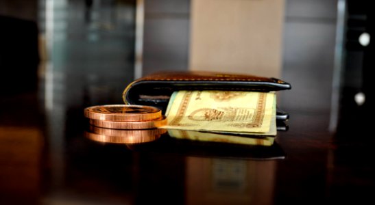 Brown Leather Bifold Wallet With Banknotes Sticking Out photo