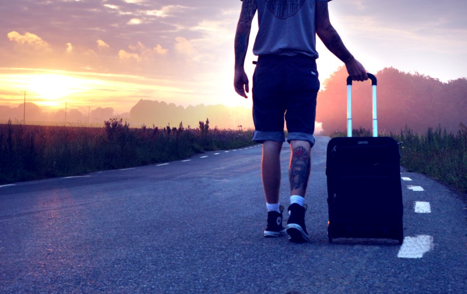 Man With Luggage On Road During Sunset