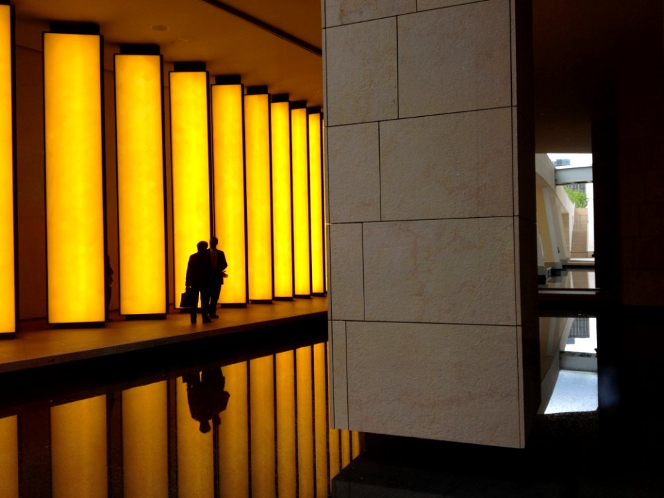 Silhouette Photo Of 2 Person Beside Beige Concrete Lighted Wall photo