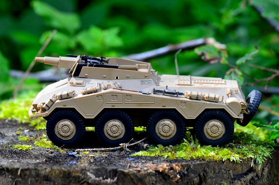 Tan Military Artillery Vehicle Toy On Wood Stump