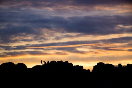 Silhouette Of 4 Persons Resting On Top On Mountain During Dusk photo