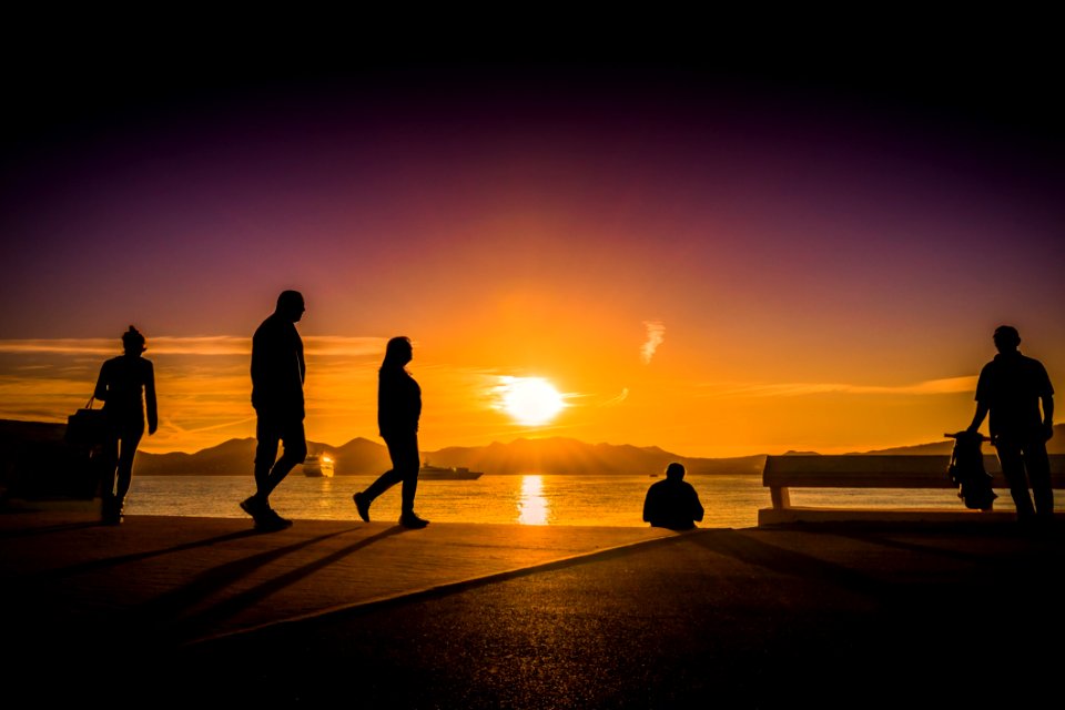 Silhouette Photography Of People Near Body Of Water photo