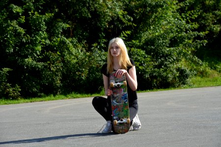Woman In Black Shirt And Pants Holding Skateboard During Daytime photo
