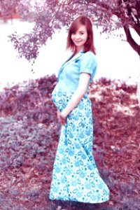 Woman In Blue Maternity Coat And White And Blue Floral Maternity Dress