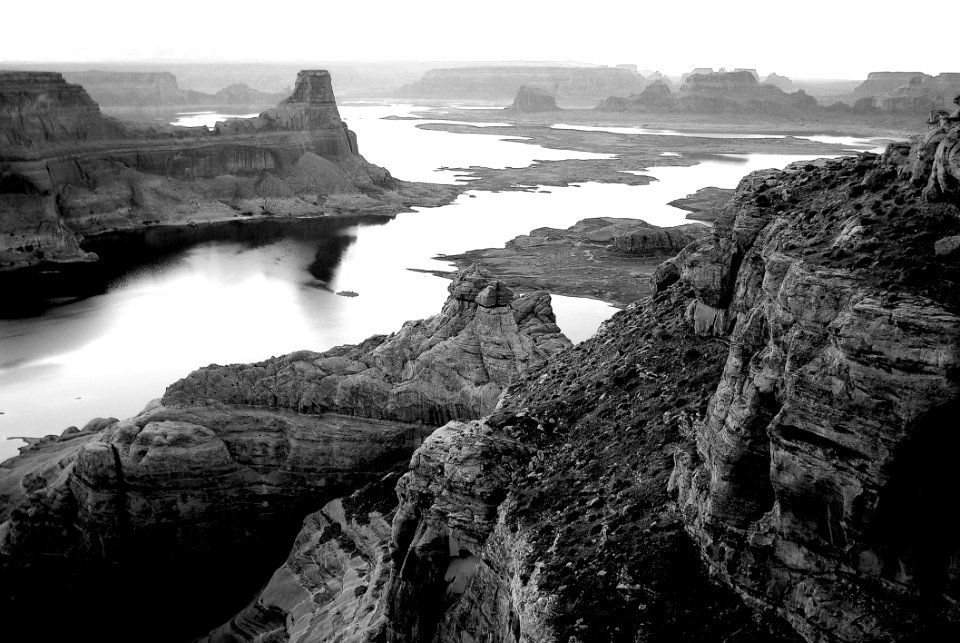 Grayscale Photography Of High Rise Rock Near Body Of Water photo