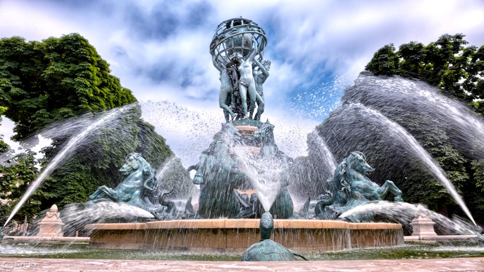 Blue Concrete Water Fountain Near Green Trees Under White Clouds photo