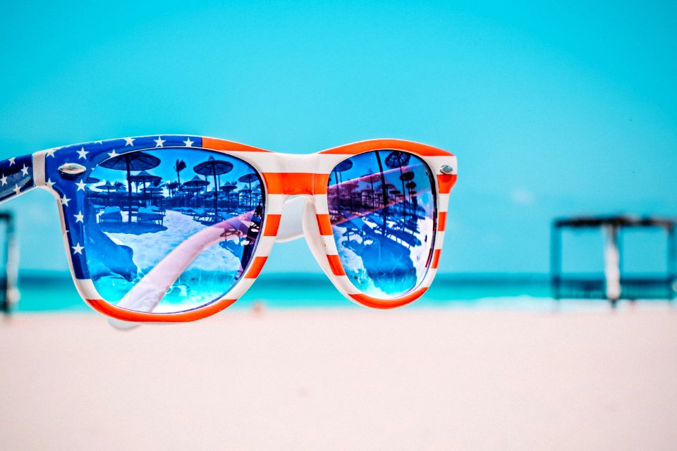 Focus Photography Of American Flag-accent Wayfarer-styled Sunglasses With Sea Background