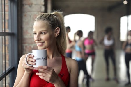 Woman Wearing Red Tank Top Holding White Ceramic Mug photo