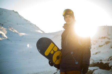 Man In Blue Pullover Hoodie Holding Blue And Yellow Snowboard photo