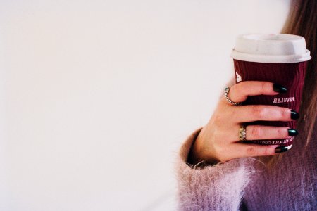 Person With Black Manicured Nails Holding Brown Cup With White Lid photo
