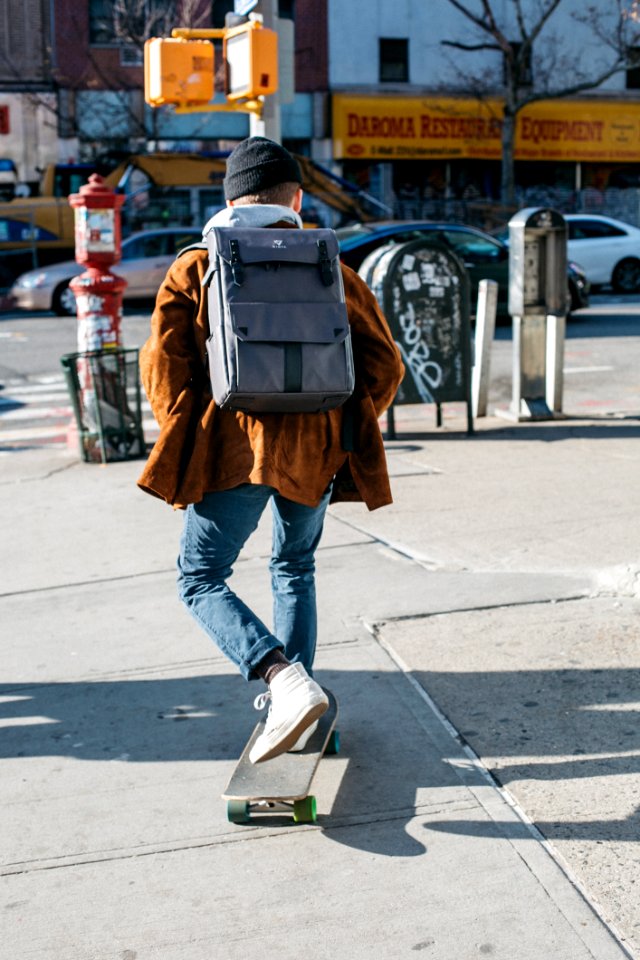 Man Wearing Brown Jacket Blue Denim Jeans And White Shoes Riding Skateboard On Sideway