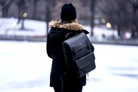 Woman Wearing Parka And Carrying Backpack During Winter photo