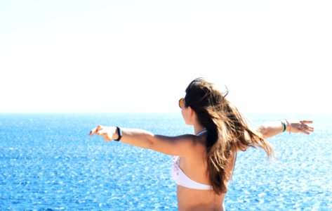 Woman Wearing White Bikini Top Standing Near Body Of Water photo