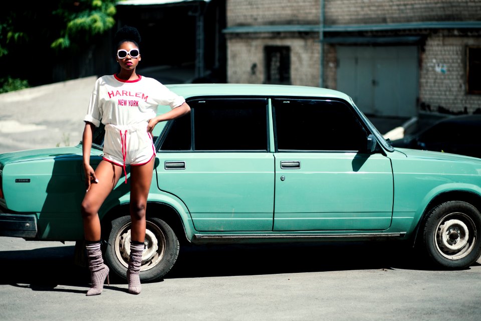 Woman Standing In Front Of Teal Sedan photo