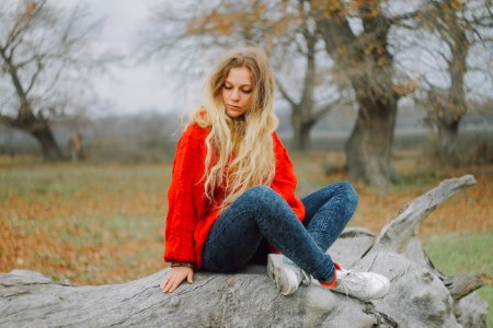 Woman In Red Sweater Sitting On Cutted Tree photo