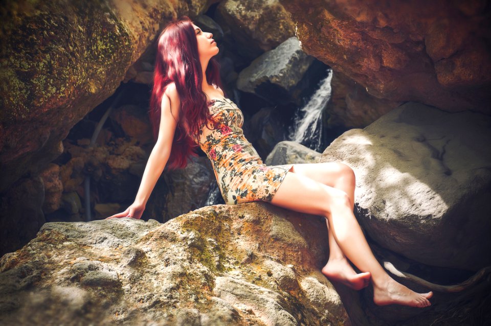 Woman In Bodycon Mini Dress Sitting On Boulder