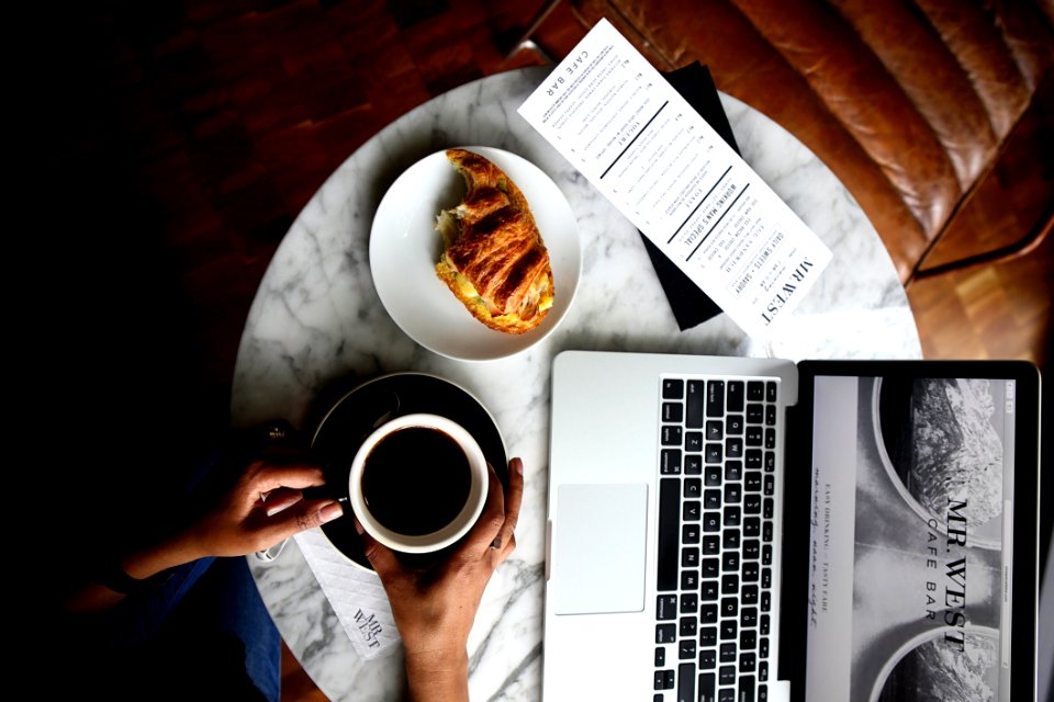 Macbook Pro And A Cup Of Coffee On Table