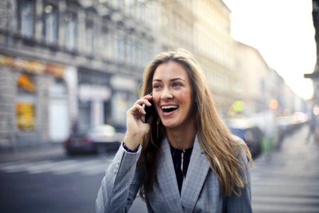 Blonde Hair Woman Wearing Gray Suit Jacket Holding Smartphone photo