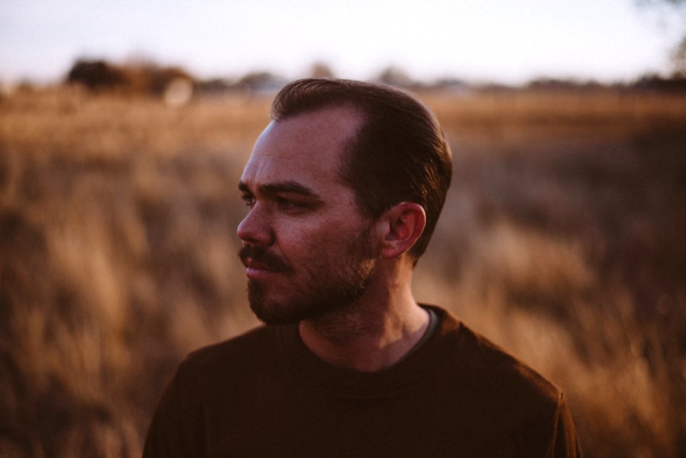 Man Wearing A Brown Crew-neck Shirt On A Field