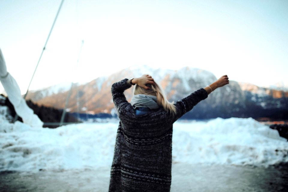 Woman In Gray And Black Tribal Cardigan Standing In Front Of Snow Fields
