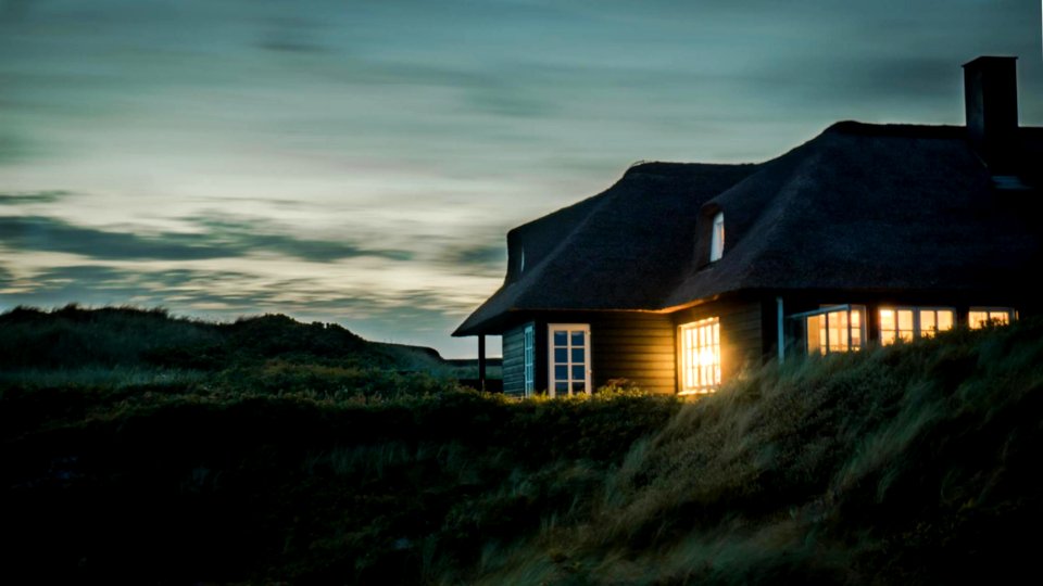 Gray House With Fireplace Surrounded By Grass Under White And Gray Cloudy Sky