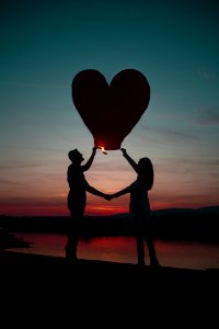 Silhouette Photo Of Man And Woman Holding Heart Lantern photo
