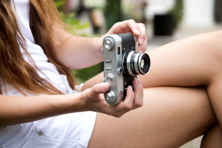 Woman Holding A Gray And Black Adjustable Lens Camera