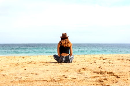 Woman Sitting On Seashore At Daytime photo