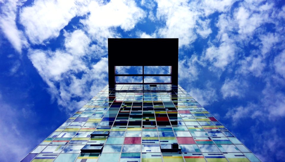 Low Angle Photography Of Glass Building Under White Cloud And Blue Sky During Daytime photo