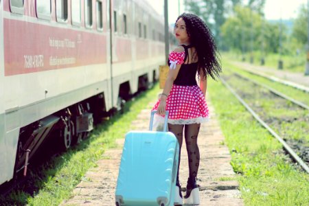 Young Woman With Luggage Standing On Train In City photo