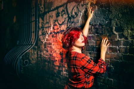 Woman In Red Black And White Plaid Holding Gray Concrete Wall photo