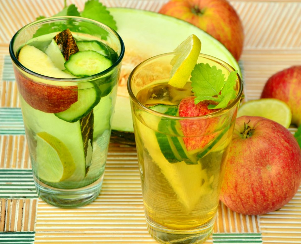 Clear Glass Cup With Fruits And Water Inside Beside Slice Fruitas