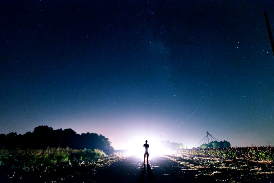 Man Standing On The Road Near Green Grass During Sunrise