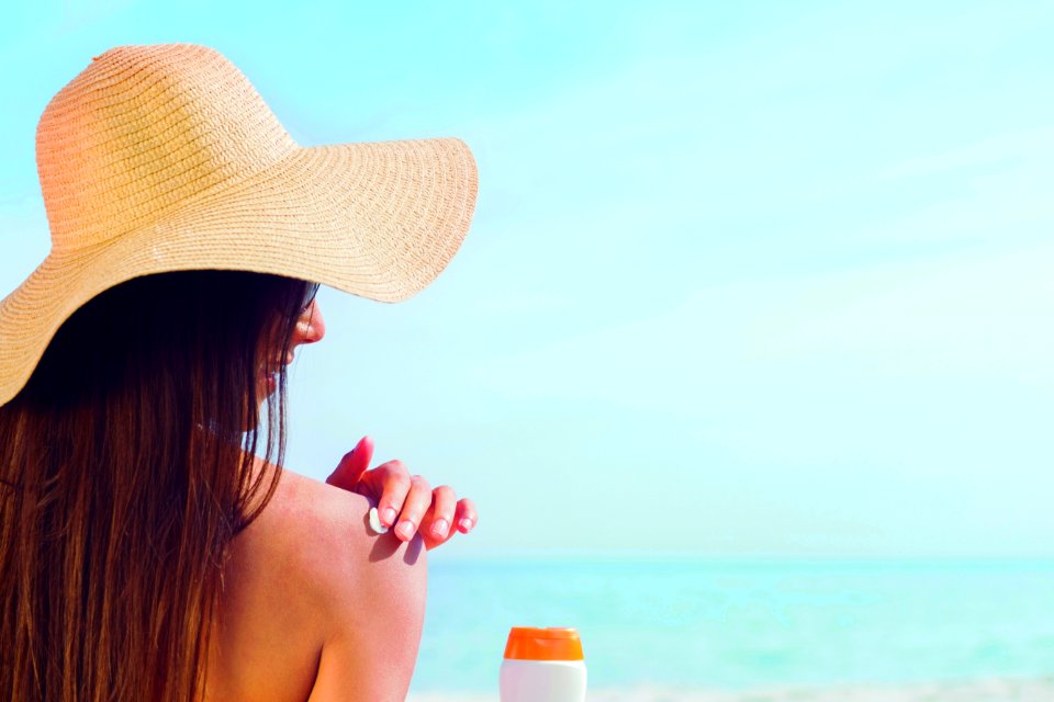 Brunette Putting Sunscreen On Her Shoulder