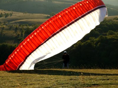 Man On The Ground With A Red Black And White Parachute photo